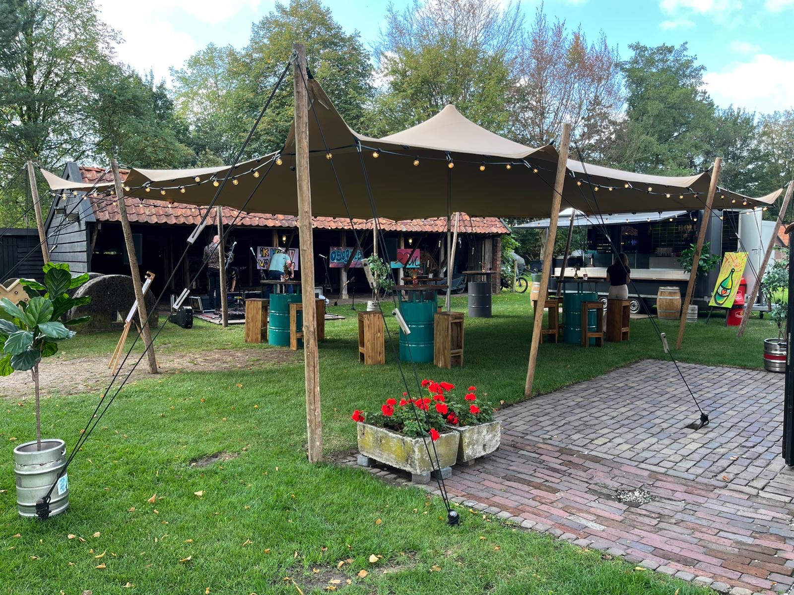 Stretchtent met sfeerverlichting en statafels voor catering op locatie