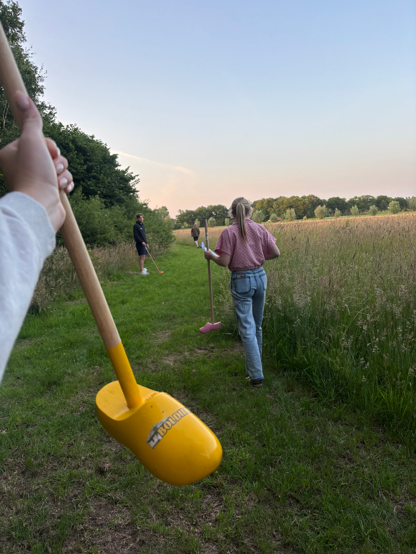 Boerengolf met klomp-club bij zonsondergang op De Boldiek