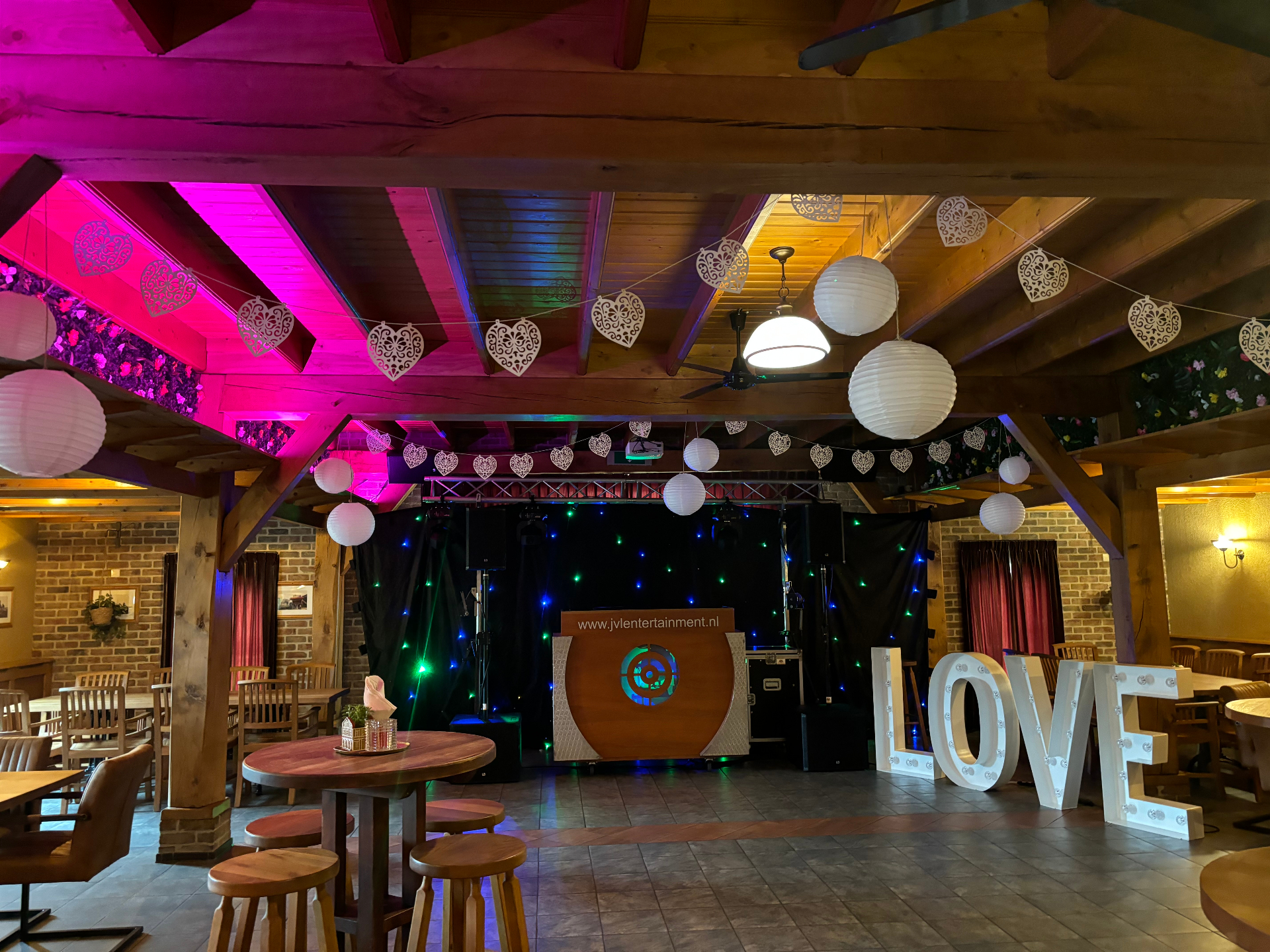 Feestzaal met LOVE-letters en sfeerverlichting voor bruiloft